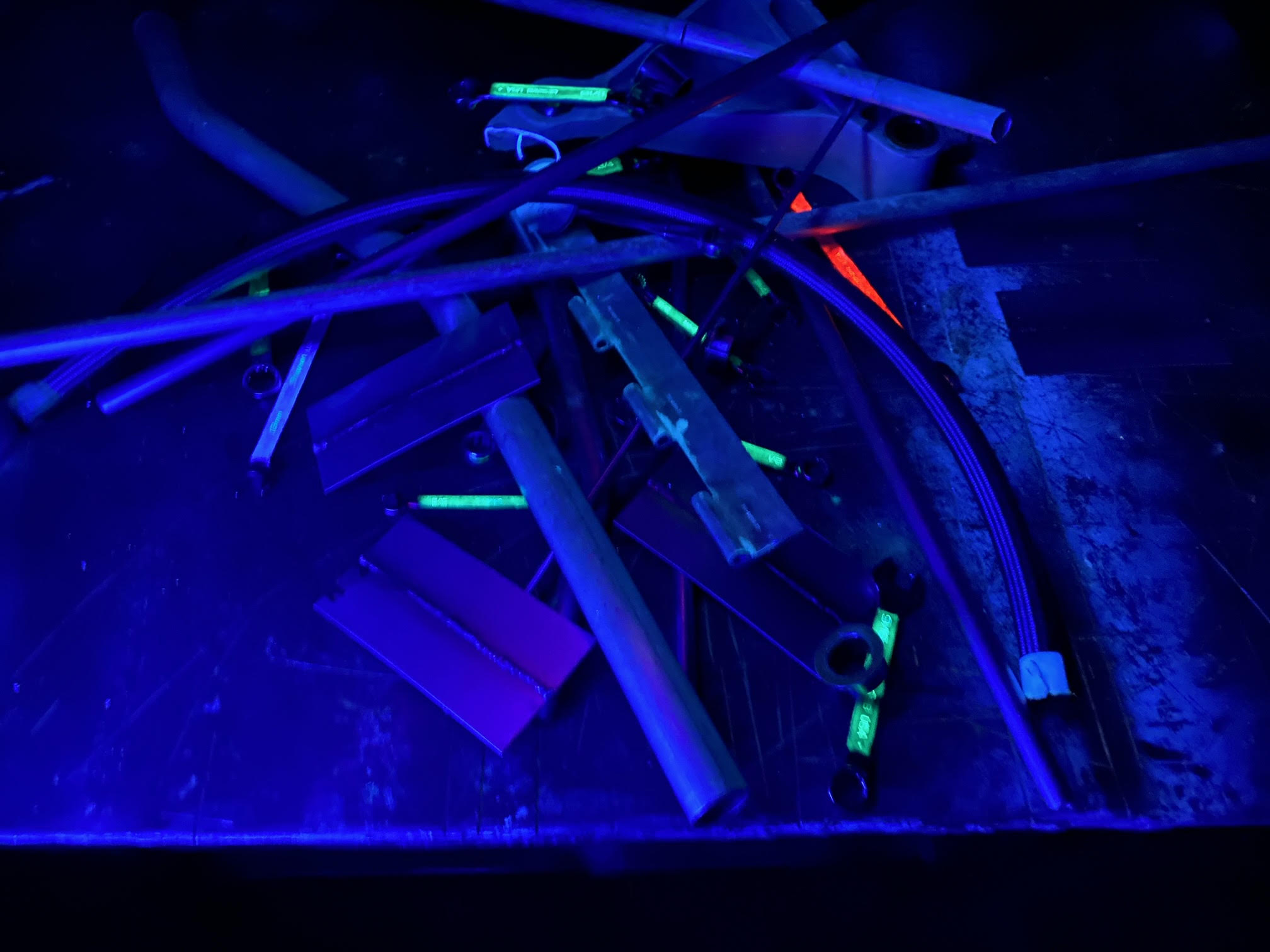 Metal rods and components fluorescing under UV light